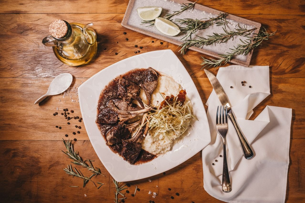 Lamb chops with risotto served on a rustic wooden table